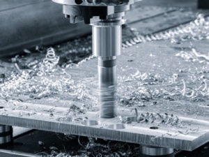 A CNC milling machine cuts metal on a worktable, showcasing precision in CNC machining processes.