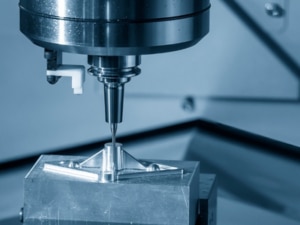 A CNC milling machine operates on a metal piece, showcasing precision machining in action.