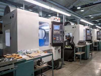 A spacious room filled with multiple CNC machines, showcasing a modern manufacturing environment.